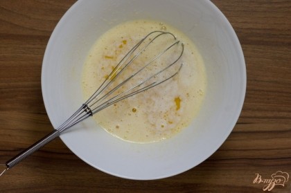 Взбейте яйца с сахаром и солью. Добавьте растопленное сливочное масло, остывшее до комнатной температуры. Перемешайте.
