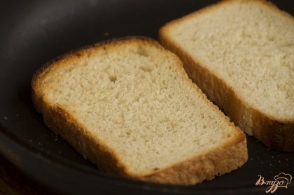 Ломтики хлеба подсушите (любым способом - на сухой сковородке, в тостере, в духовке). Натрите разрезанным зубком чеснока. Выложите помидорную смесь.