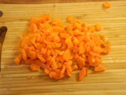 Отварную морковь почистить, мелко порезать и добавить в салатницу