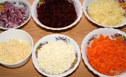 Свеклу,морковь и картофель завернуть в фольгу и запечь в духовке или отварить. Печеные овощи очистить и натереть на крупной терке по отдельности. Сыр натереть на средней терке. Яйца отварить,очистить и мелко нарезать. Лук мелко нарезать,добавить лимонный сок,перемешать и оставить на 5-10 минут.