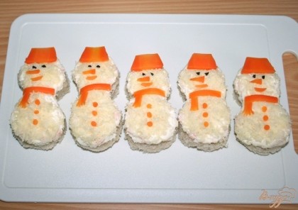 Бутерброды оформить в виде снеговиков вареной морковью и маслиной.