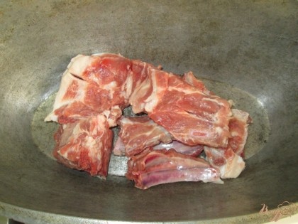 В казан или толстостенную кастрюлю складываем свиные ребра,
