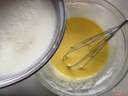 Добавьте горячие молоко в яичную смесь постоянно помешивая венчиком.