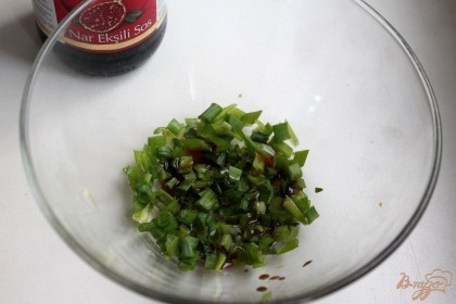 Мелко режем зеленый лук и заливаем его гранатовым соусом.