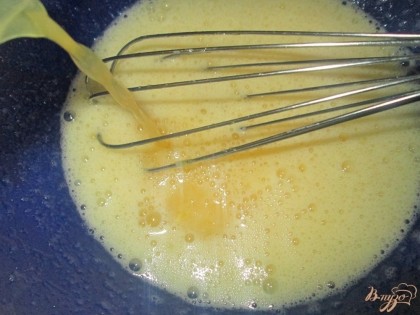  Выжать сок апельсина (должно получиться около 60-70 мл), и сок   добавить к взбитым яйцам. Добавляем ванильный сахар и ростопленное сливочное масло, все хорошо перемешиваем.