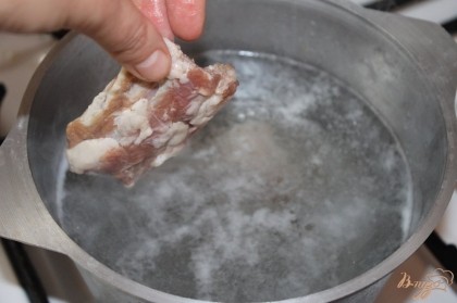 В горячую воду кидаем ребра и варим 10 минут, добавляем картофель.
