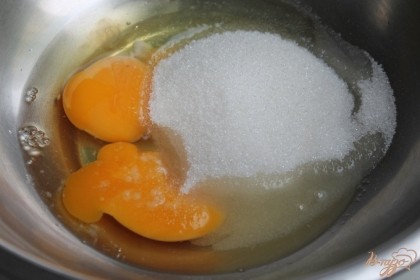 В миску насыпаем сахар, вбиваем яйца и перемешиваем с помощью блендера.