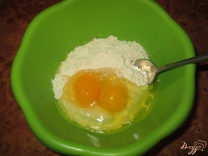В миску всыпать два стакана муки, разбить два куриных яйца,