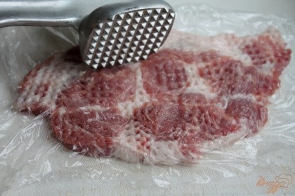 Свинину нарезаем кусками толщиной 1 см. и отбиваем. Для удобства мясо покрываем пищевой пленкой.