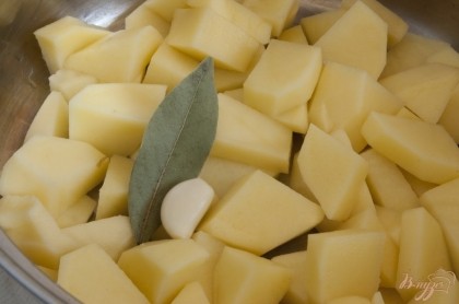 Добавить лавровый лист и очищенный зубок чеснока, залить водой (или бульоном / отваром). Варить до полной готовности картофеля.