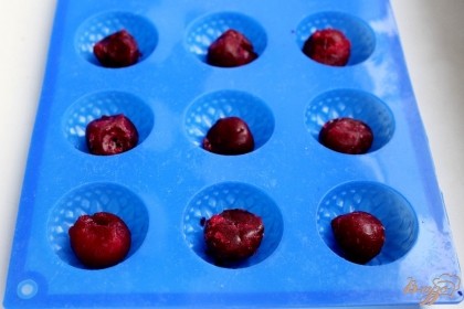В силиконовые формы кладем вишни и заливаем их тестом.