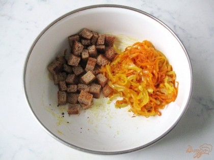 В миску кладем сухарики и лук с морковью.