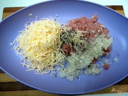 Натираем на тёрке сыр, добавляем к фаршу, солим, перчим. Не добавляйте в фрикадельки яйцо, оно придаст им жёсткость.
