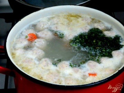 Когда овощи закипят, отправим в суп фрикадельки, зелень, соль, перец. Затем суп нужно потомить минут 10 на маленьком огне.