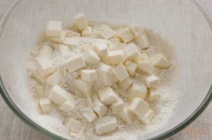 Муку (350 г) просеять в миску, добавить соль, перемешать, добавить сливочное масло (200 г), нарезанное кубиками.
