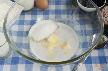Масло положить в миску, где будет замешиваться тесто. В микроволновке слегка растопить его, даже скорее подтопить. Добавить половину сахара, соль, ванильный сахар, перемешать.