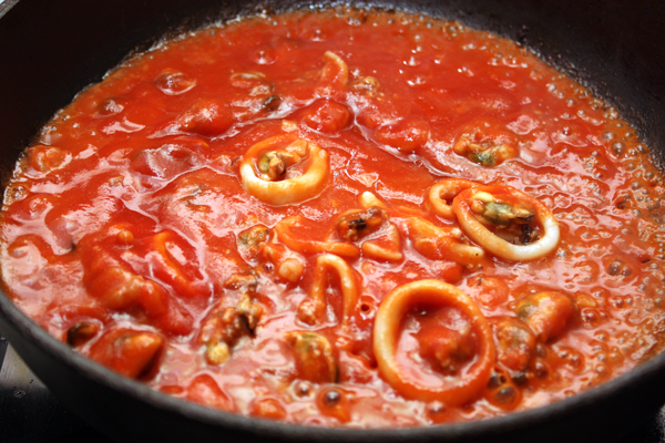 Теперь выкладываем в сковороду томатное пюре (или просто очищенные и мелко нарезанные помидоры). Готовим еще пару минут, чтобы жидкость немного выкипела.