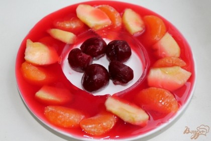 Вишневое желе застыло. Стакан вынимаем, в центр тарелки кладем вишни без косточек. Если вишня мороженная, предварительно размораживать ягоды не нужно.
