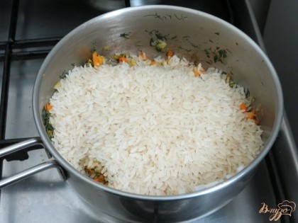 На пассерованные овощи выложить рис и залить холодной водой. Варить до готовности 20 минут.