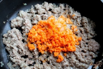 Небольшую морковь, пропущенную через мясорубку, добавляем в сковородку к мясу с луком. Солим и обжариваем минут 10.