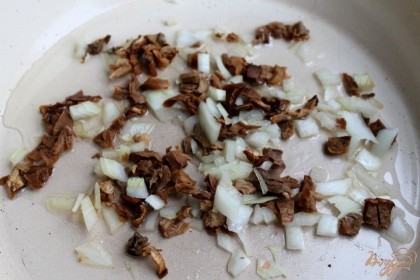 Нарезаем на кусочки грибы и репчатый лук. На сковородку с растительным маслом выкладываем порезанные грибы с луком и обжариваем 15 минут на слабом огне.