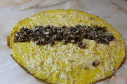 Когда омлет готов, в средину кладем предварительно обжаренные грибы с луком на растительном масле до золотистого цвета.