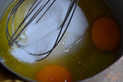 В сотейнике растопить масло, всыпать сахар и добавить 2 яйца. Энергично взбить венчиком.