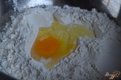 В большую миску насыпать муку с разрыхлителем, сахар и соль.Выбить 1 яйцо.