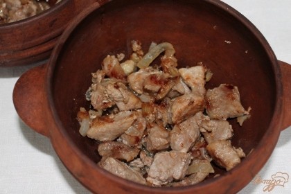 Обжариваем мясо с луком 10-15 минут и перекладываем в глиняные горшочки.