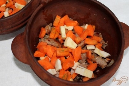 Морковь и пастернак чистим и режем кусочками. Порезанные овощи высыпаем к мясу.