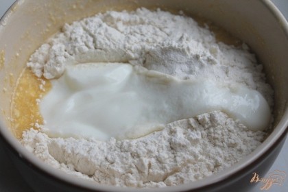 Далее насыпаем разрыхлитель, пшеничную муку и натуральный йогурт.  Вместо йогурта можно использовать кефир.