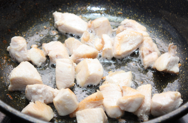 Куриную грудку (берем одно филе на порцию) режем кусочками и обжариваем на горячей сковороде до золотистого цвета, чуть посолив.