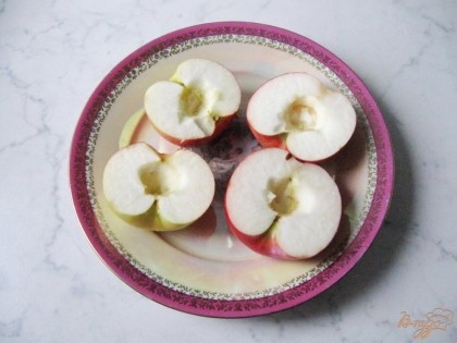 Яблоки моем и разрезаем на две половинки. Вырезаем семенную коробочку.