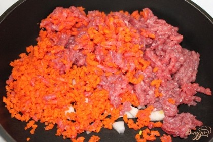 Через мясорубку пропускаем говядину и морковь. Сковородку с подсолнечным маслом ставим на огонь и выкладываем перекрученную говядину, морковь и порезанный репчатый лук.
