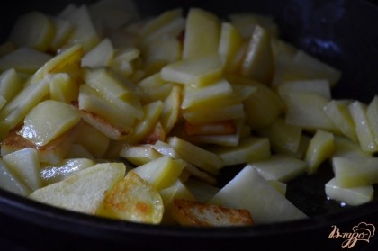 На сковороде нагреть масло и выложить картофель.Первые 10 минут готовим на сильном огне и под закрытой крышкой.