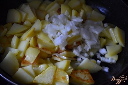 Затем добавить мелко нарезанный лук, соль и специи.Обжариваем до готовности картофеля, перемешивая время от времени широкой лопаткой.