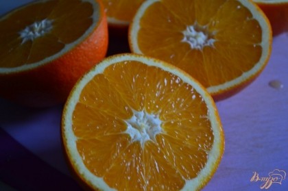 Апельсины разрезать на две части.