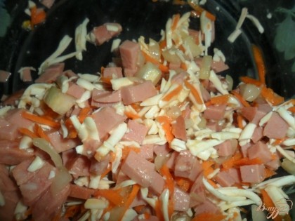 Приготовить начинку: колбасу и лук мелко порезать, морковь и сыр натереть на терке, добавить сырое яйцо и все перемешать.