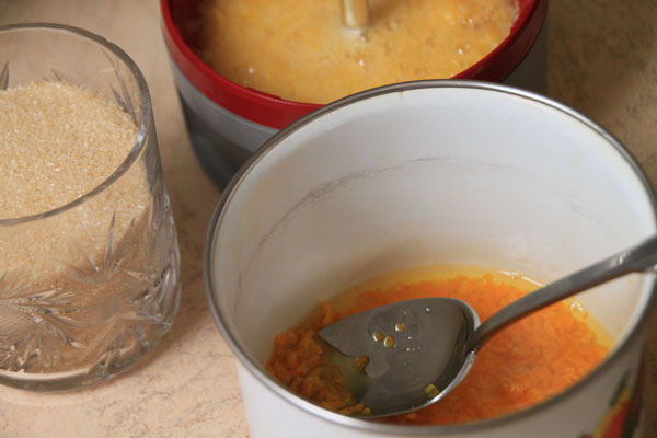 В кастрюльку с апельсиновыми корочками вылейте сок и всыпьте стакан сахарного песка. Положите гвоздику и поставьте снова на маленький огонь ещё на 20 минут. Периодически помешивайте джем, чтобы он не подгорел.  В отдельной мисочке замочите половину столовой ложки желатина в двух-трёх столовых ложках воды. Минут через 10 растопите на маленьком огне (не доводя до кипения) и смешайте с джемом.