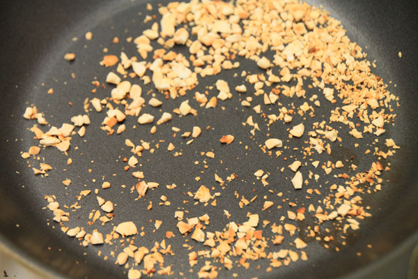 Отложенные орешки порубите не очень крупно и обжарьте на сковороде до светло-золотистого цвета.