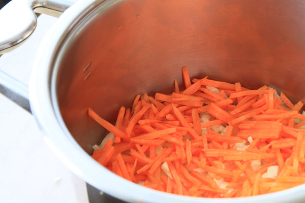 На дно холодной чистой (без масла) кастрюли слоями уложите овощи. Сначала укладываются самые сочные, некрахмалистые овощи: лук, чеснок, морковь.