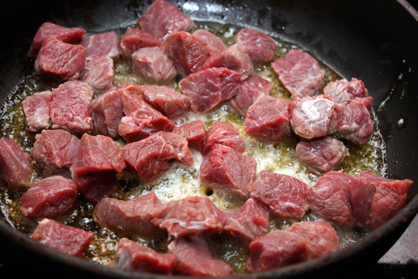 Мясо очистить от жил и нарезать небольшими кубиками, затем обжарить со всех сторон в сливочном масле. Кладите мясо небольшими порциями, чтобы оно именно жарилось, а не тушилось.