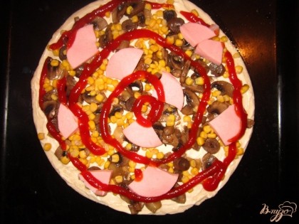 Вареную колбасу нарежьте треугольником выложите на пиццу и сверху полейте кетчупом.