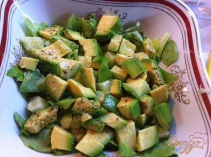 В салатник рвем руками салатные листья, добавляем авокадо и огурец.