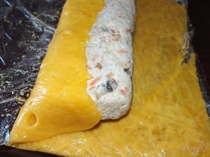 Когда сыр немного остынет, аккуратно разрезать пакет. Выложить на пласт сыра наш батончик салата, и аккуратно при помощи пакета поднять края, завернув тем самым салат в сыр. Убрать в холодильник на некоторое время