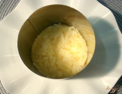 Кулинарное кольцо выкладываем на тарелку. Первым шаром в кольце выкладываем половину картофеля.