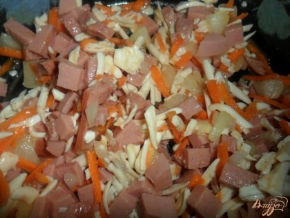 Приготовить начинку: колбасу мелко порезать, сыр натереть на терке, морковь так же натереть на терке, лук порезать, добавить сырое яйцо и перемешать.