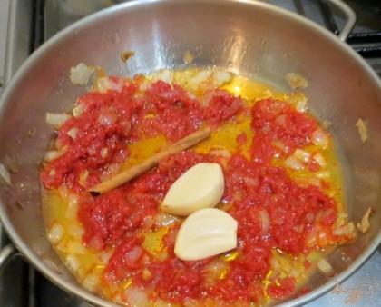 Когда лук станет мягким, добавим к нему томатную пасту, сахар,палочку корицы, два зубца чеснока. Пассеруем вместе минут 5.