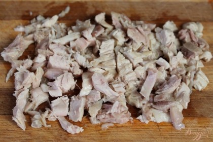 Предварительно отваренное куриное мясо нарезаем небольшими кусочками.