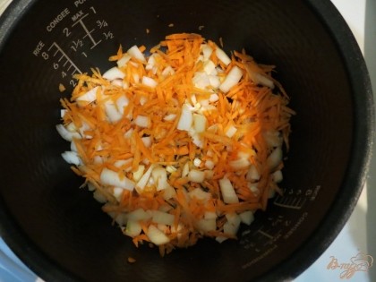 На дно чаши мультиварки наливаем 2 столовые ложки растительного масла и отправляем туда морковь и лук. Выставляем режим жарка на 15 минут.
